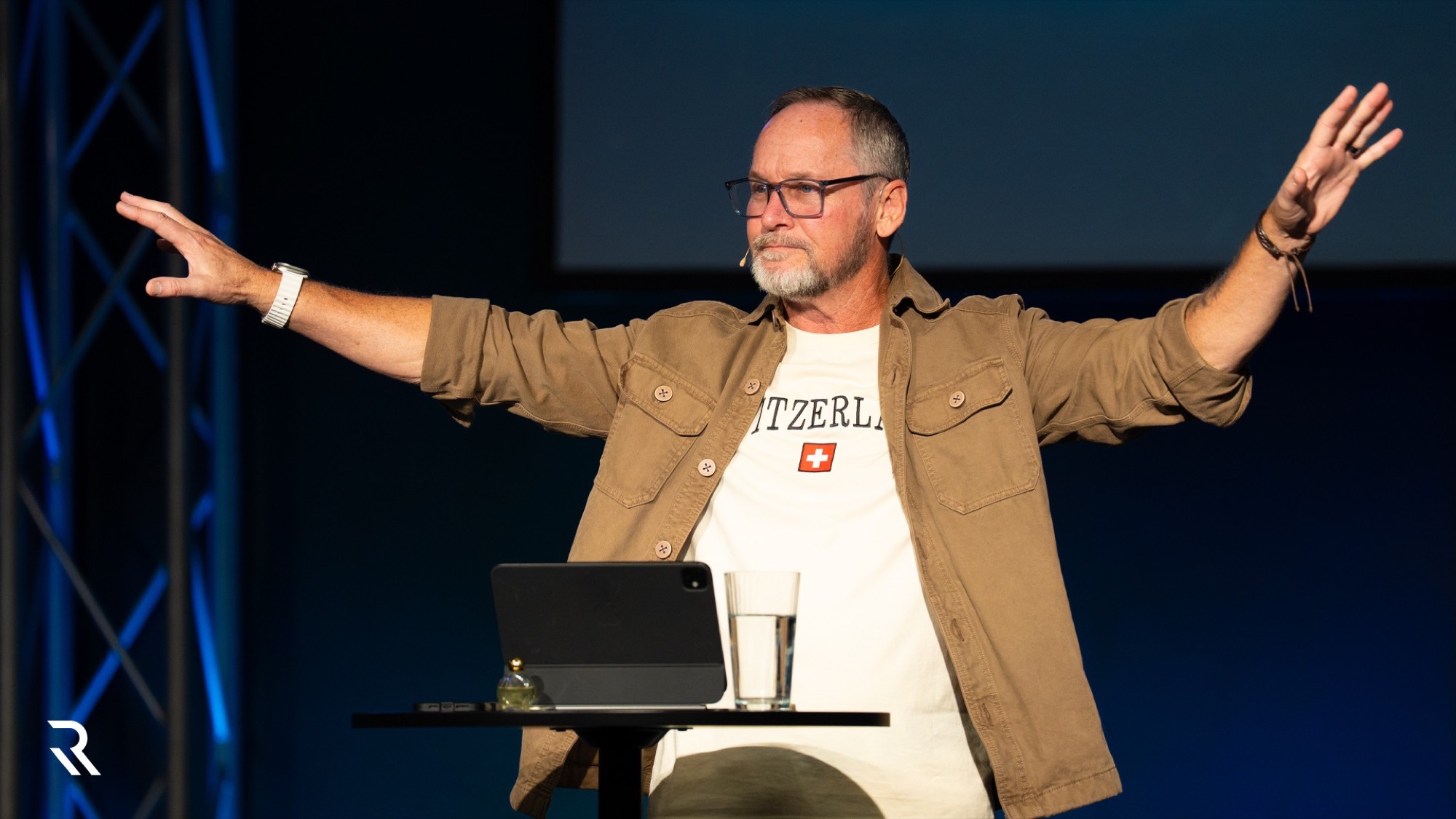 Pastor Steve Parker with arms open, teaching on a Sunday