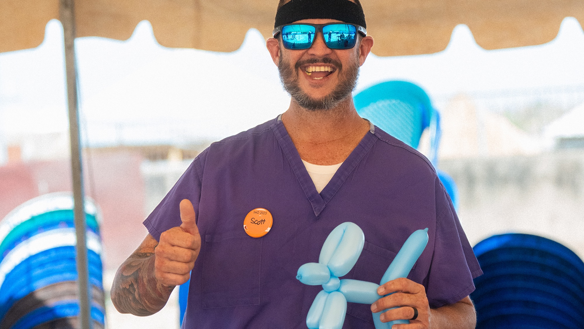 A volunteer making balloon animals at an outreach event